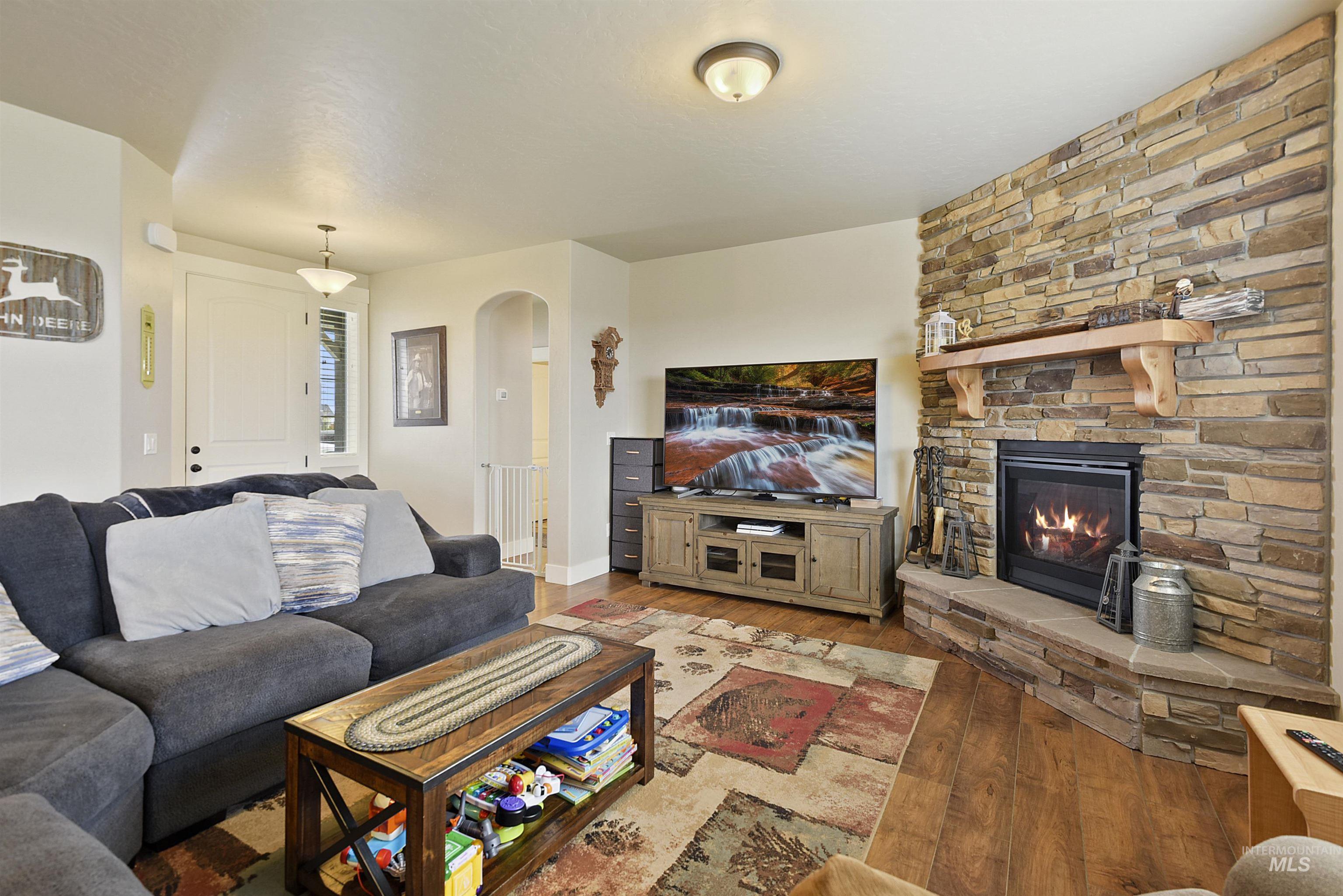 Living area featuring wood finished floors, a fireplace, and arched walkways