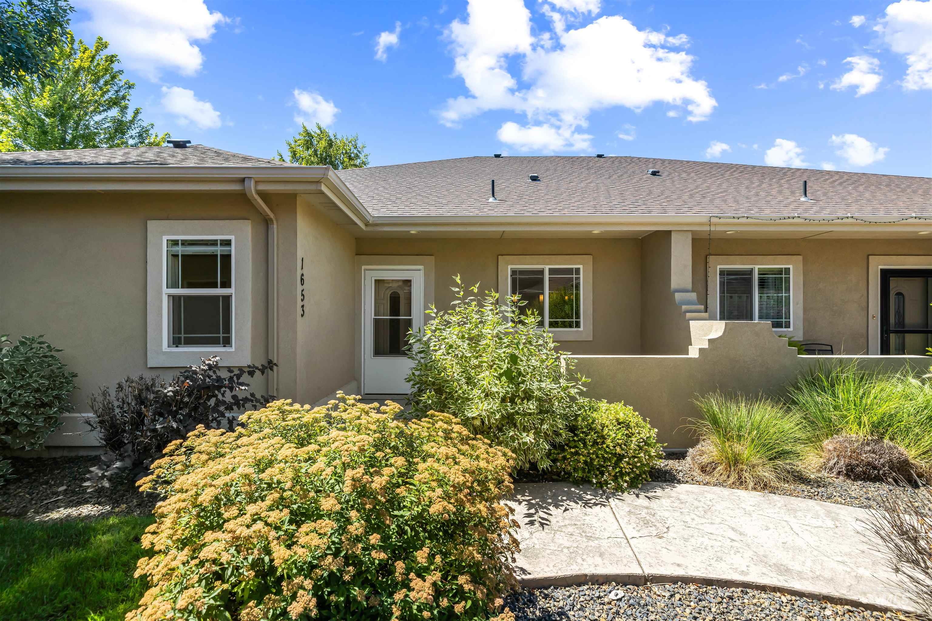 Property entrance with stucco siding and a shingled roof