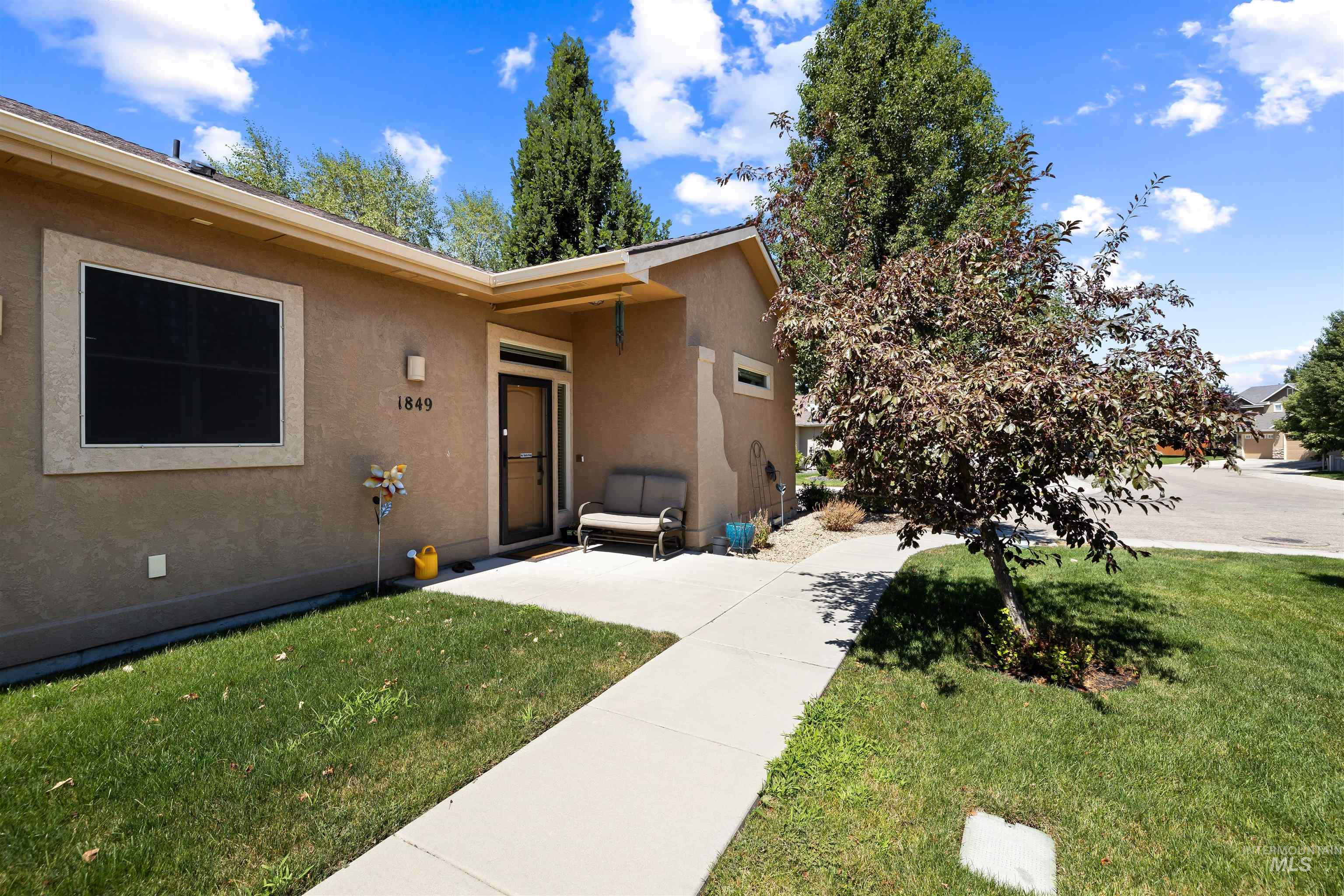 Doorway to property featuring stucco siding and a lawn