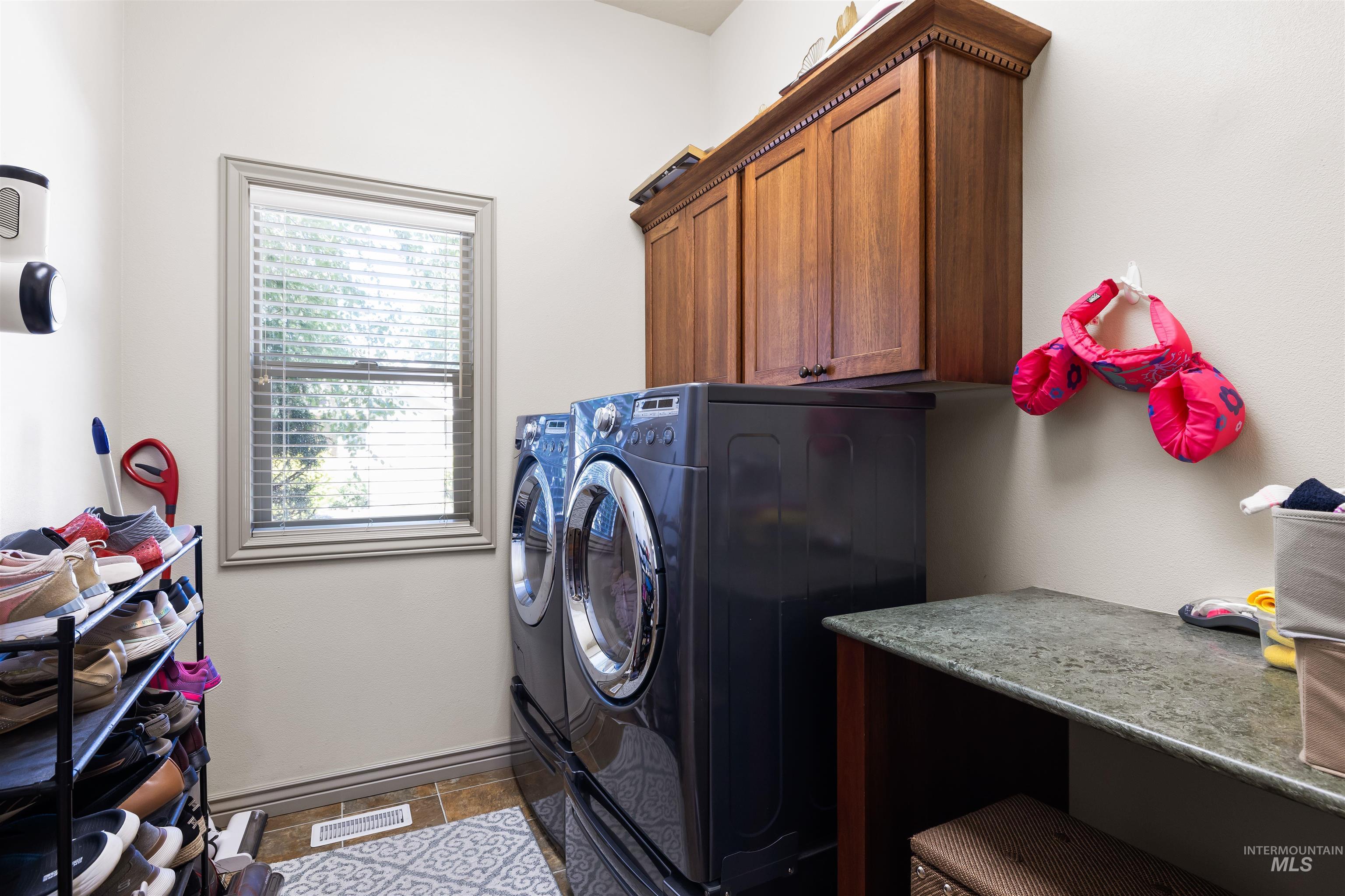 Laundry room with washing machine and clothes dryer and cabinet space