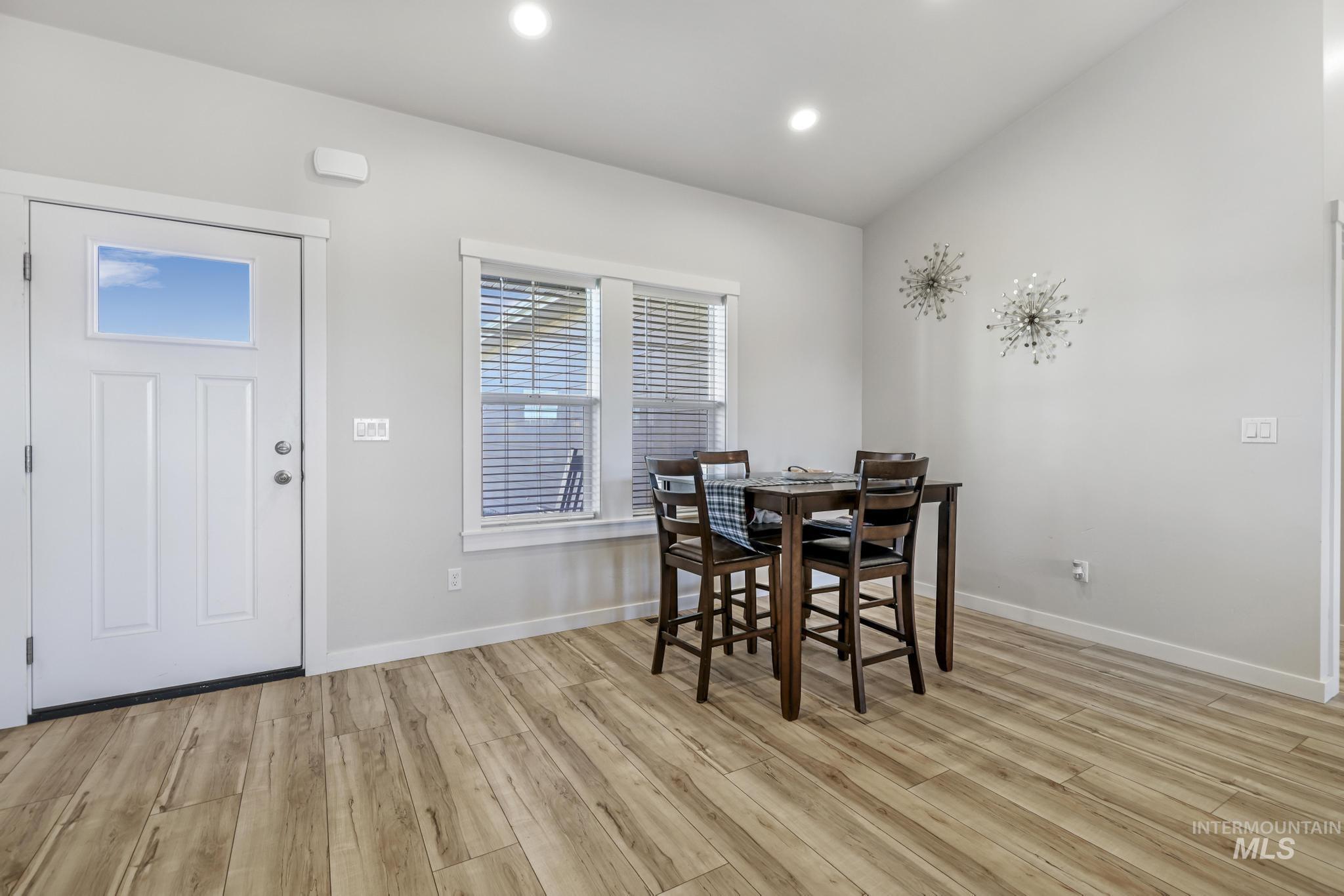 Dining area with light wood-style floors and recessed lighting