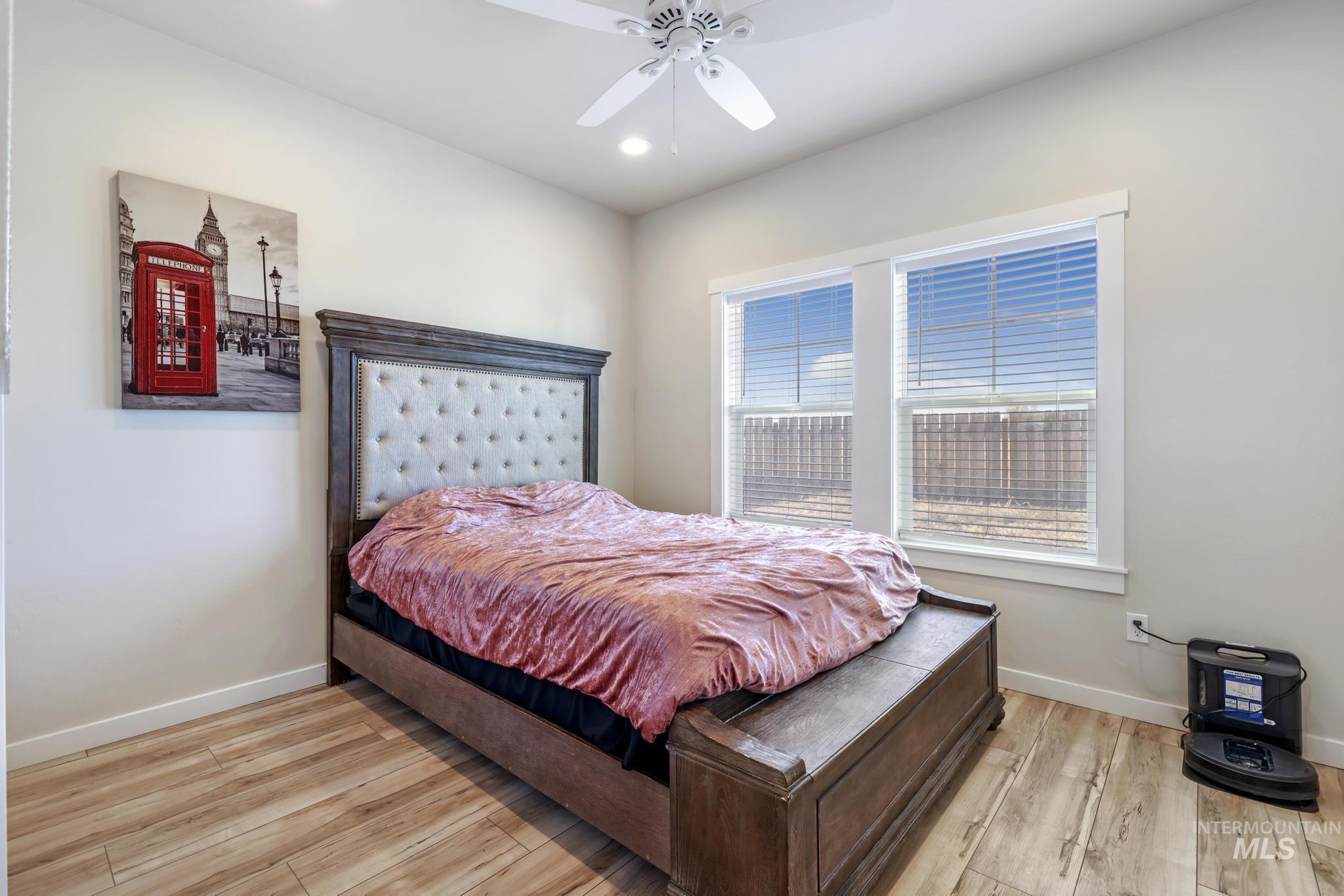 Bedroom with light wood-style floors, ceiling fan, and recessed lighting