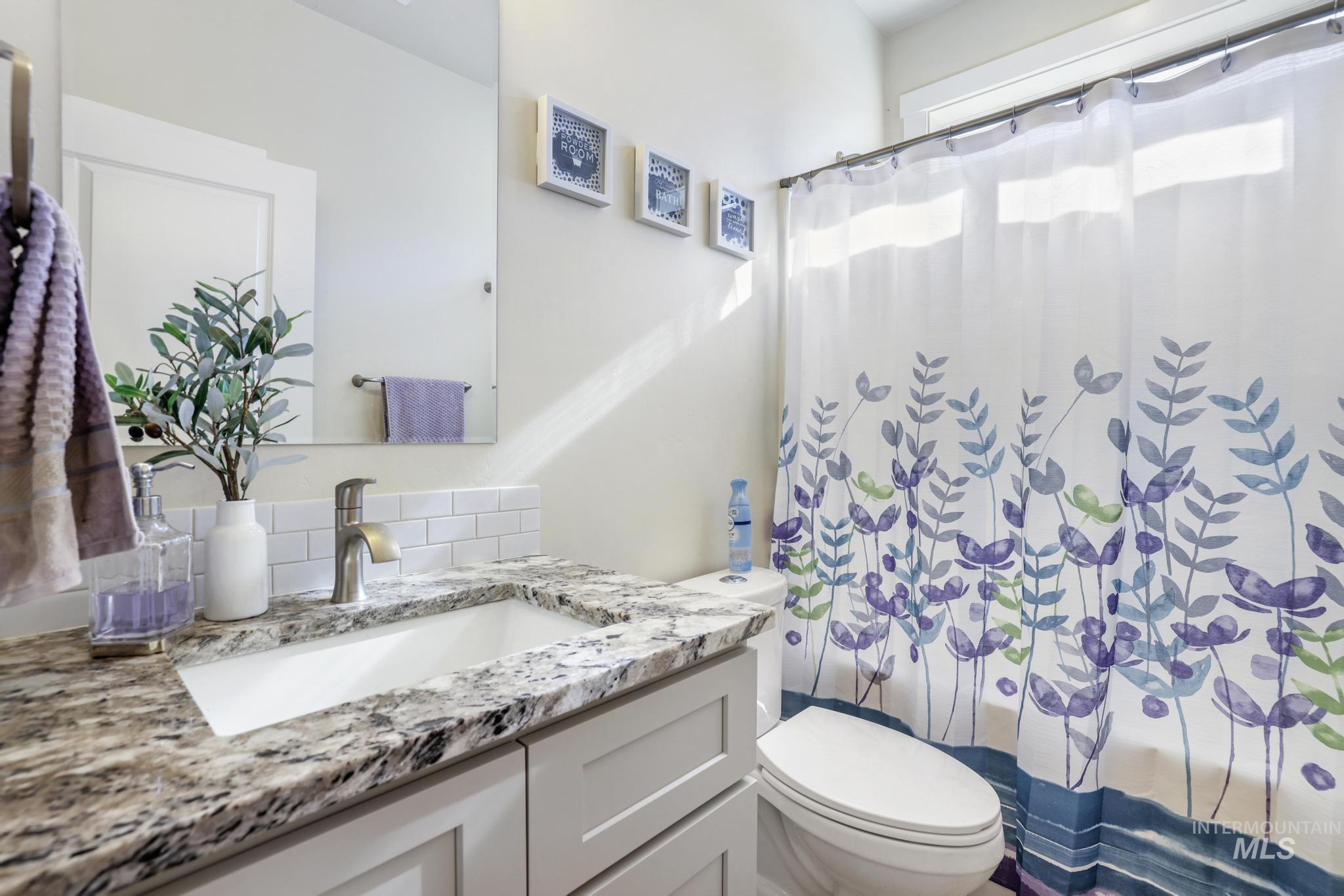 Bathroom with vanity and shower / bath combo with shower curtain