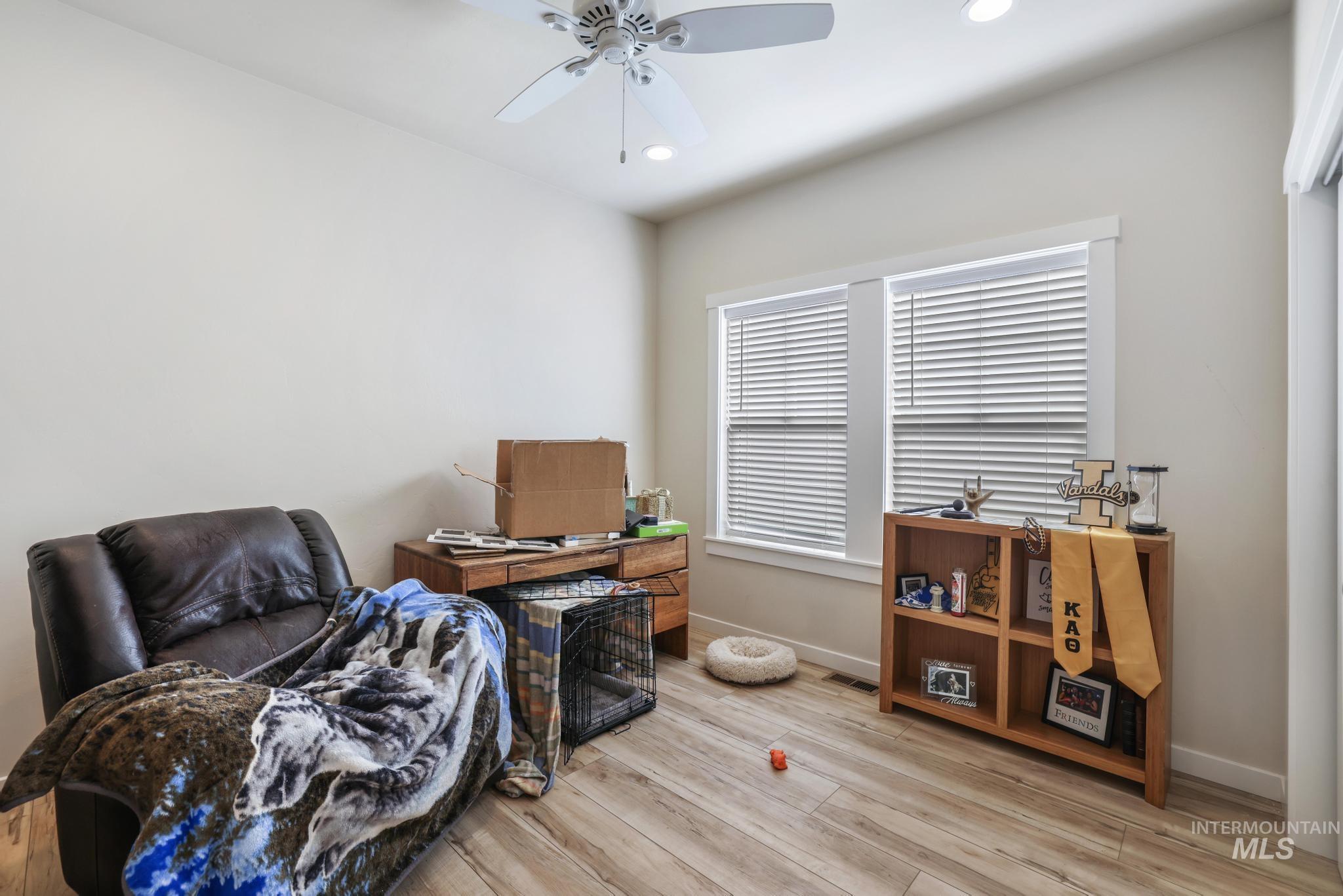 Office space with a ceiling fan, light wood-style flooring, and recessed lighting