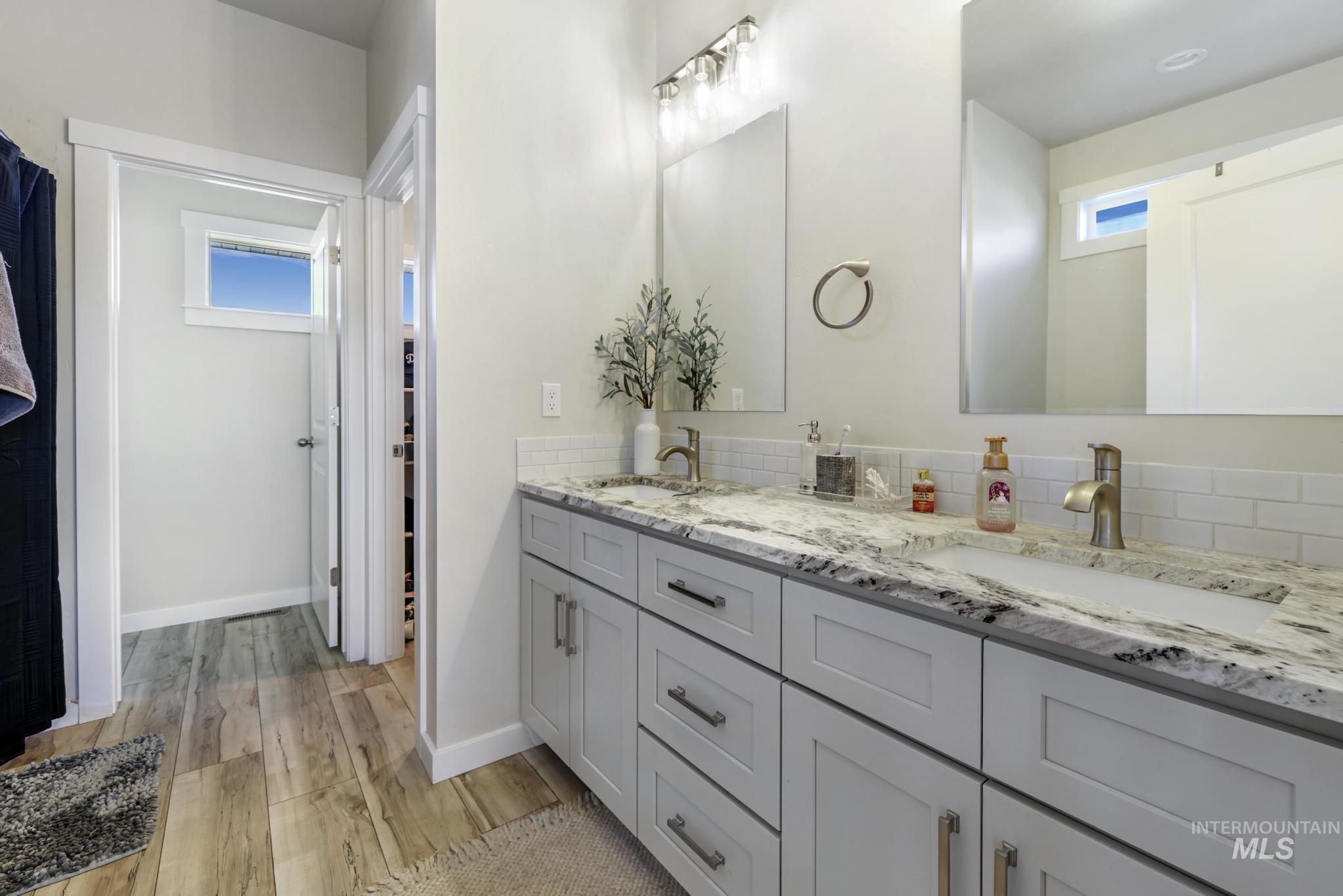 Bathroom with double vanity and light wood-style floors