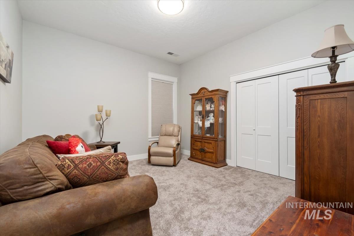Bedroom 2 with light colored carpet and baseboards
