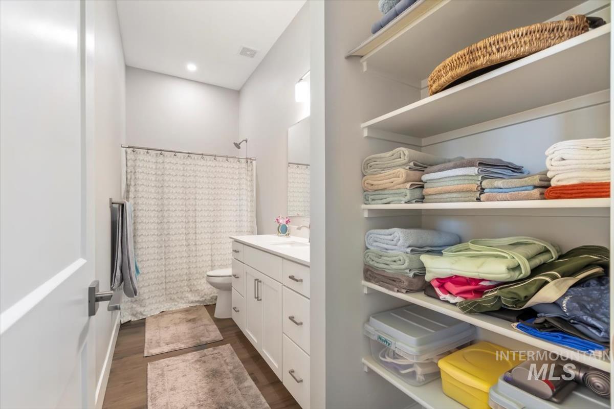 Full bathroom featuring dark wood finished floors, vanity, and a shower with curtain