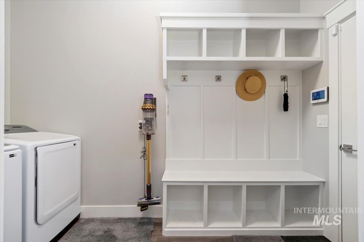 Utility/Mudroom with washer and dryer and dark wood-type flooring