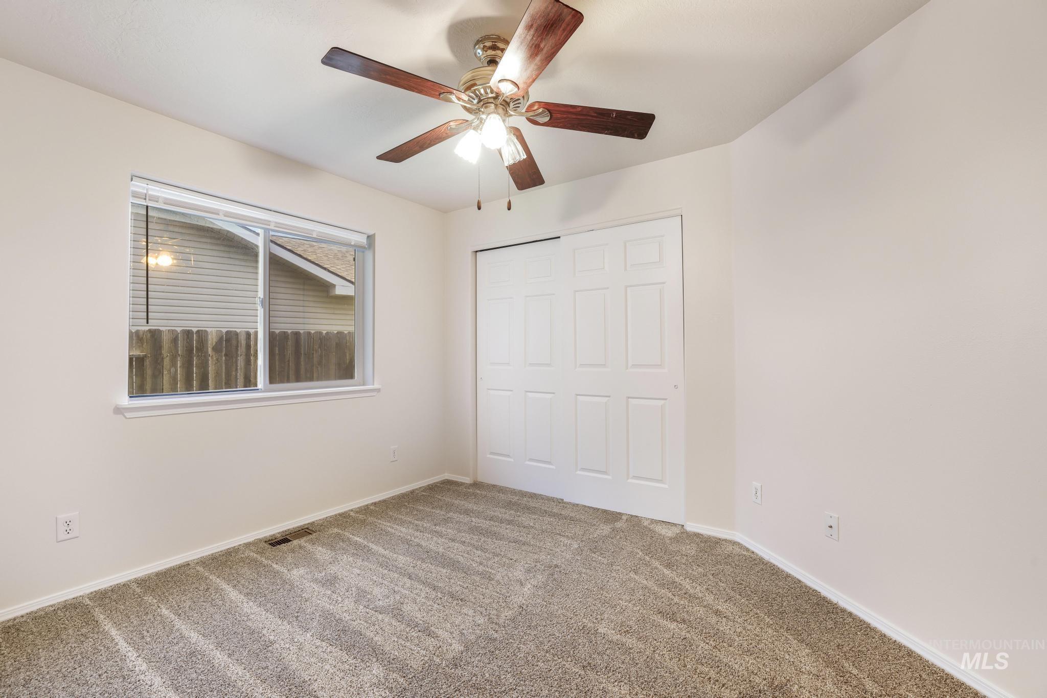 Unfurnished bedroom featuring carpet, ceiling fan, and a closet