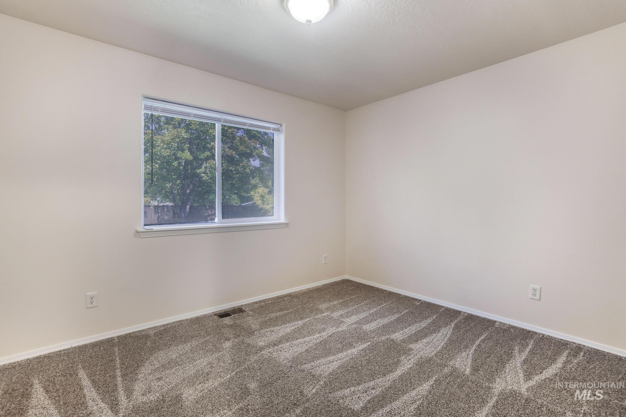 Spare room with carpet and baseboards
