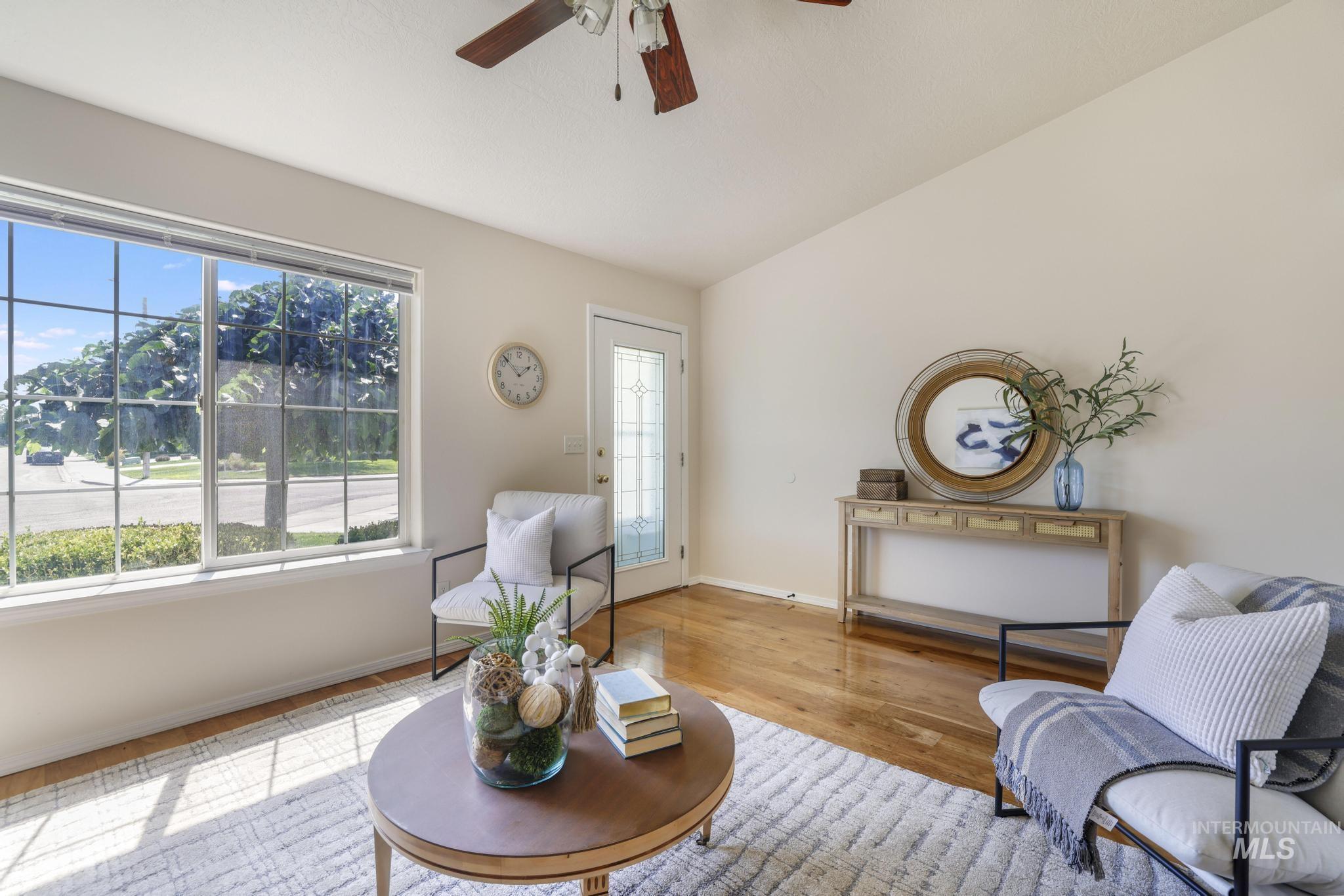 Sitting room featuring wood finished floors, a ceiling fan, and vaulted ceiling