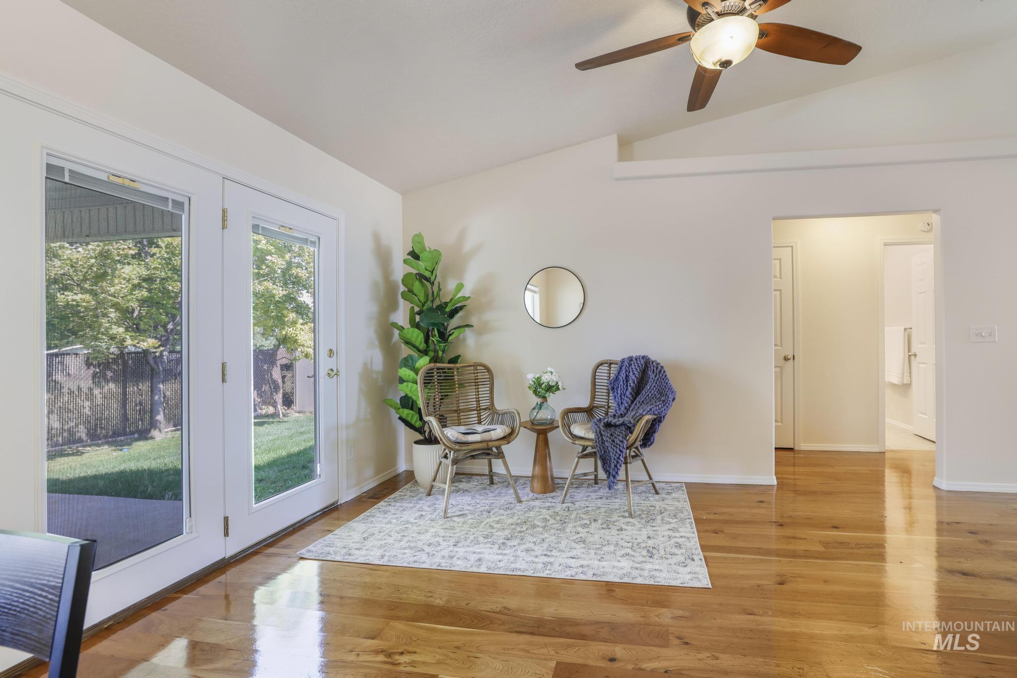 Sitting room featuring vaulted ceiling, light wood finished floors, and a ceiling fan