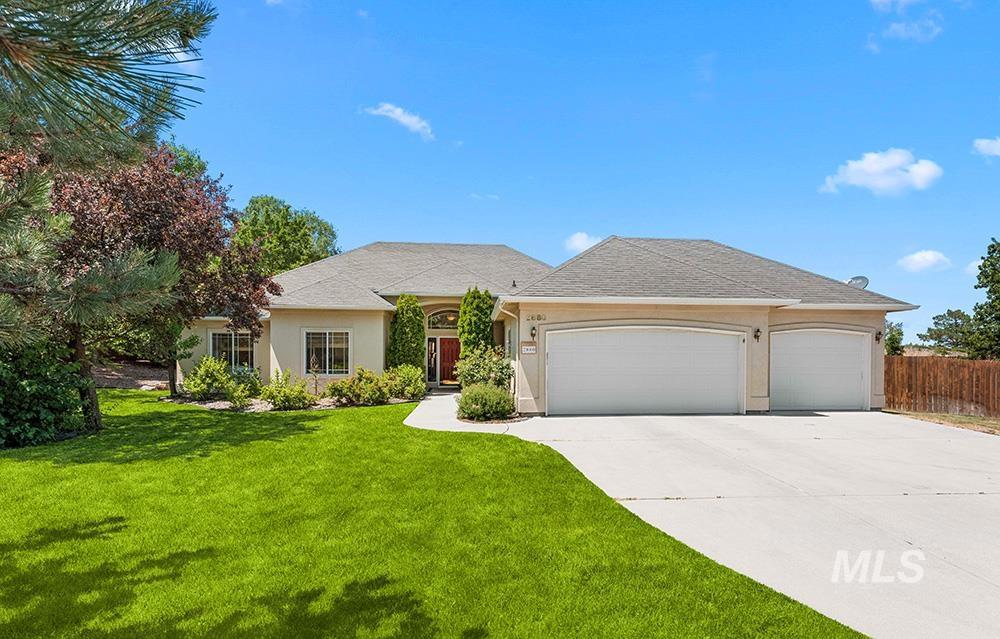 Ranch-style home featuring a garage, stucco siding, and driveway