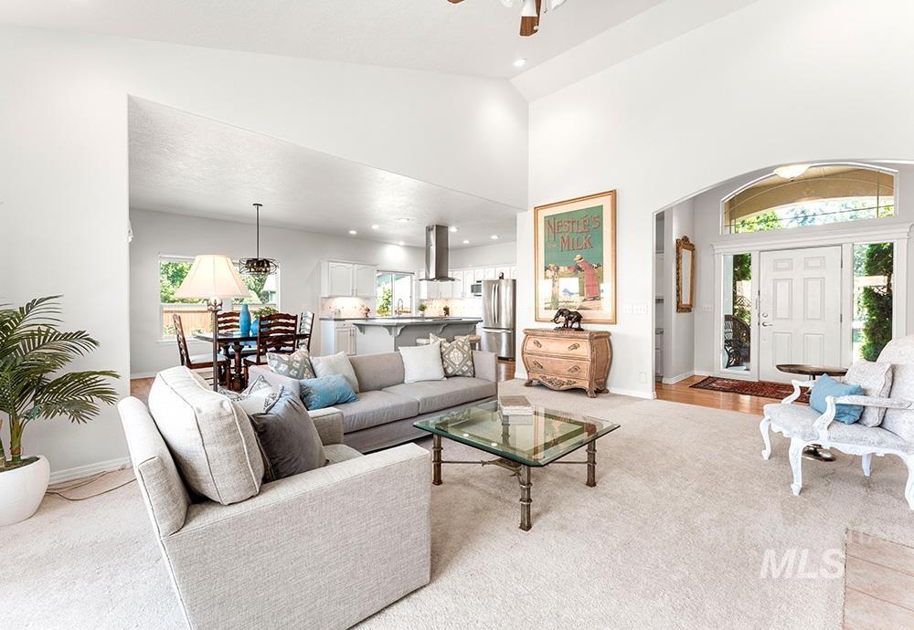 Living room with arched walkways, light carpet, a ceiling fan, recessed lighting, and a high ceiling