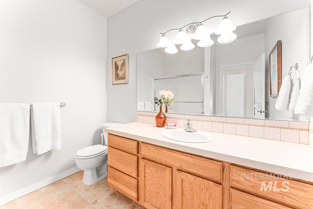 Full bathroom featuring vanity, a stall shower, and backsplash
