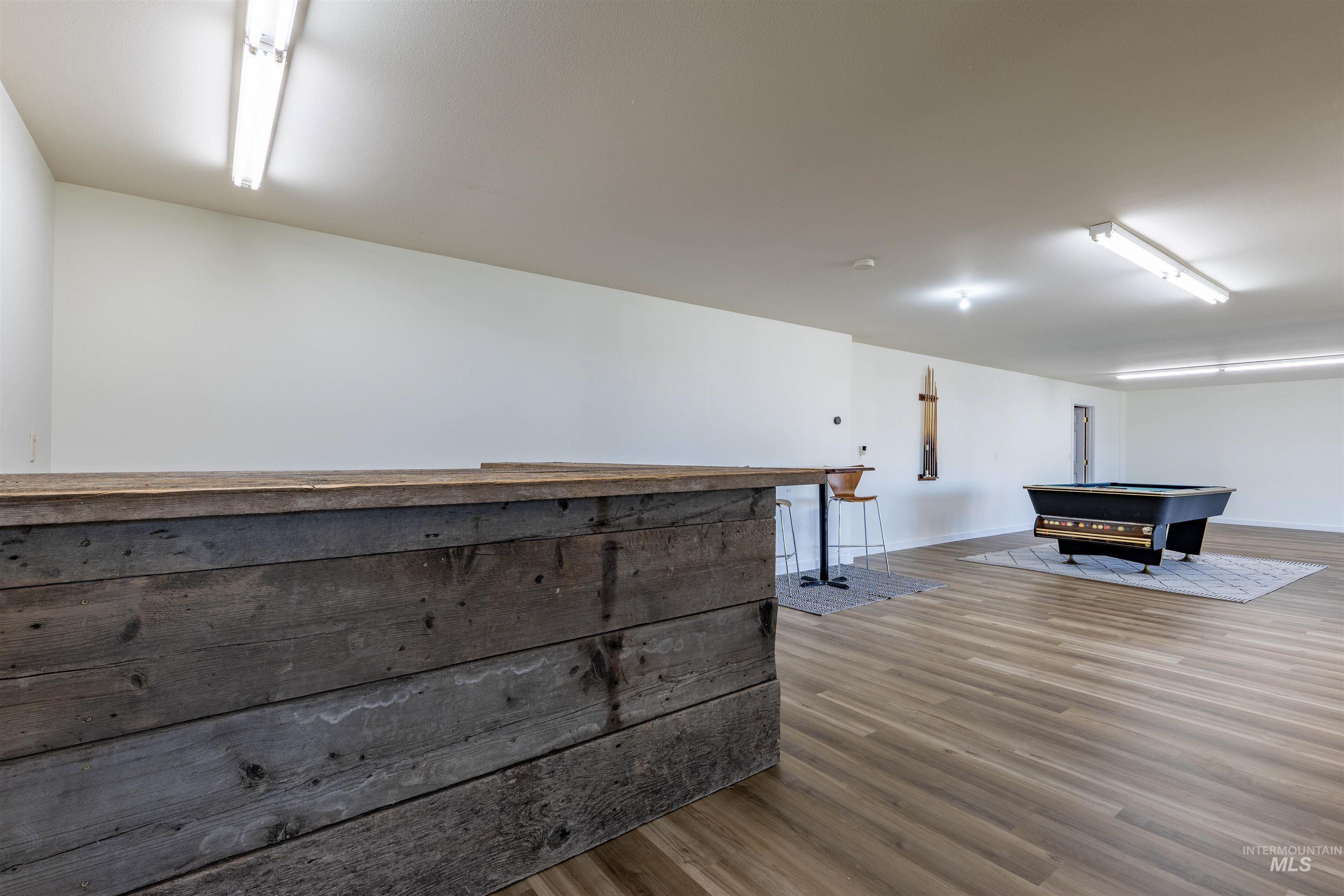 Rec room featuring light wood finished floors, pool table, and a dry bar