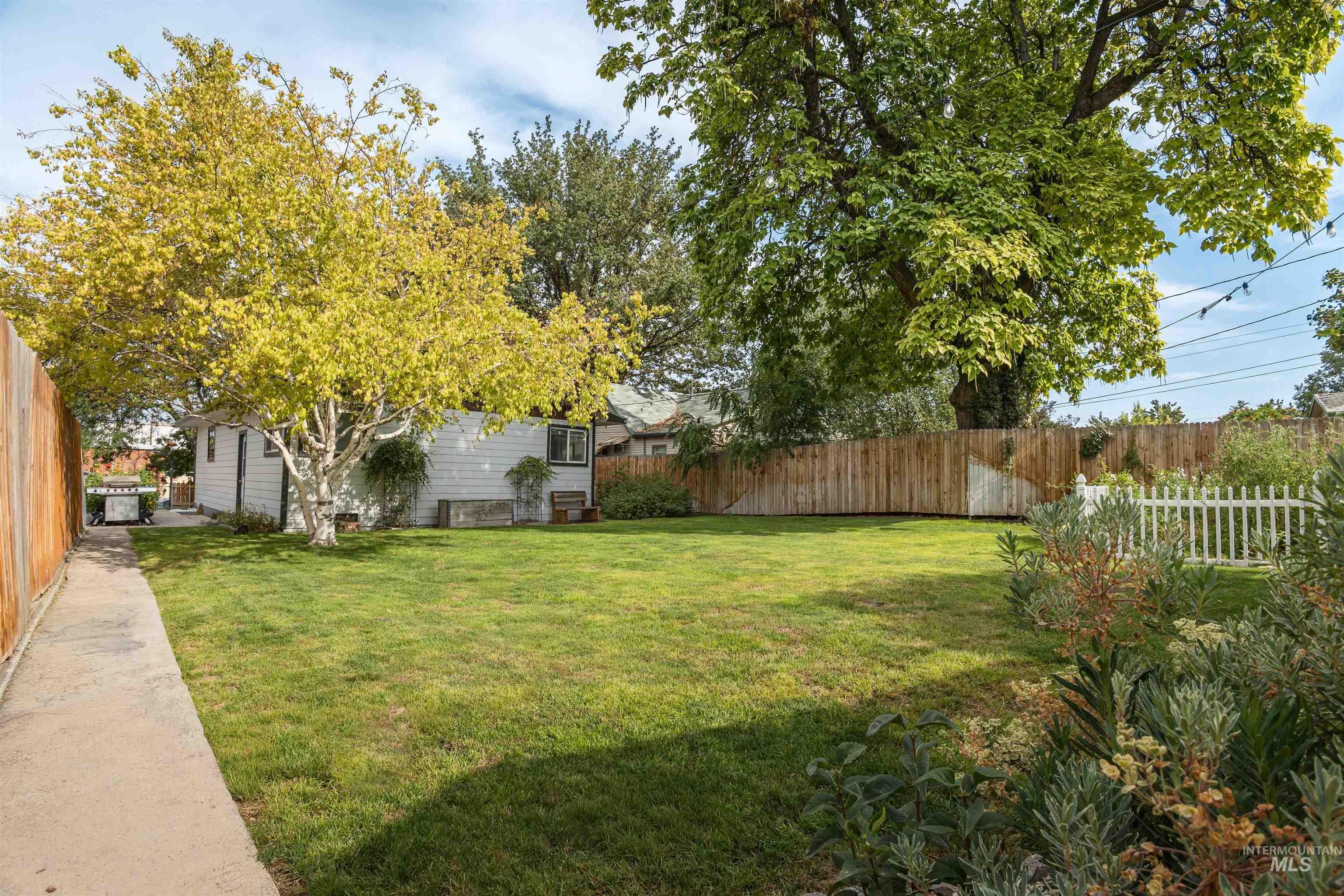 Fenced backyard featuring an outbuilding