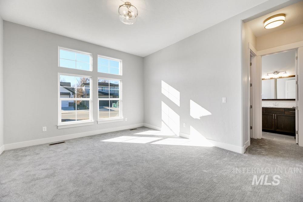 Unfurnished bedroom with light carpet and ensuite bath