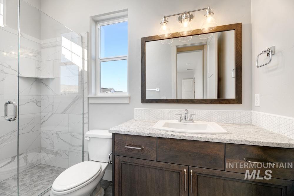 Full bathroom featuring a marble finish shower and vanity