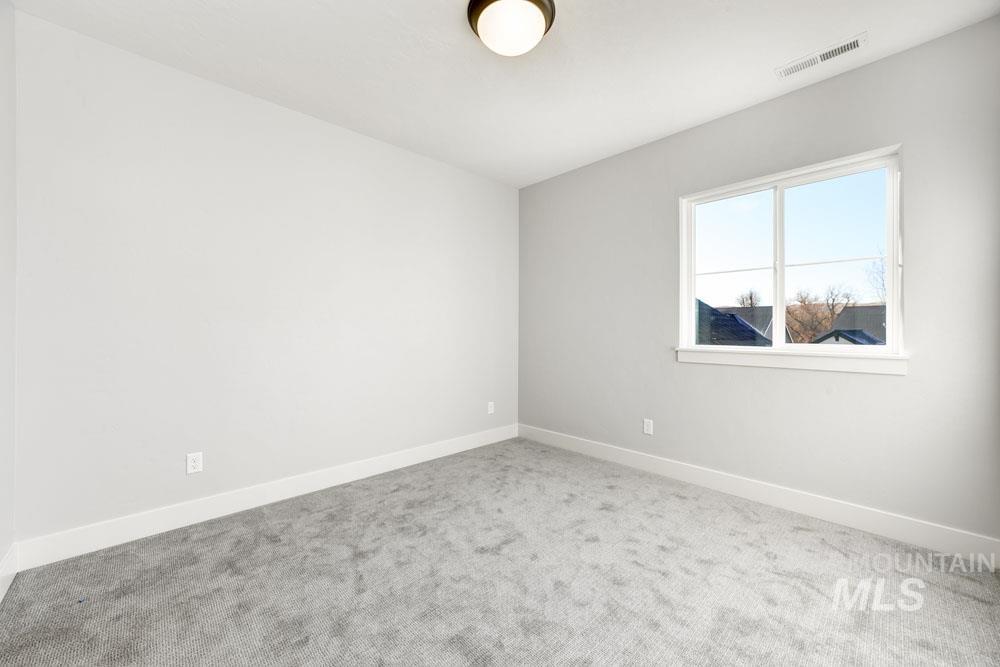 Spare room featuring carpet and baseboards