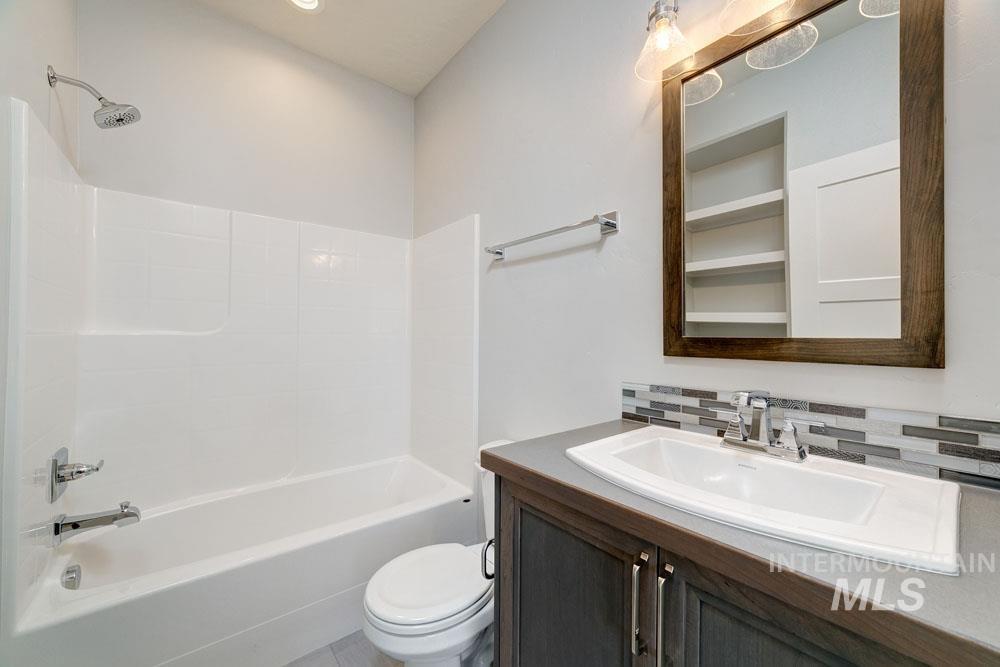 Full bath featuring bathing tub / shower combination, vanity, and tasteful backsplash