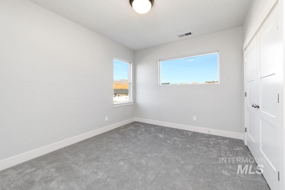 Unfurnished bedroom with a closet and dark colored carpet