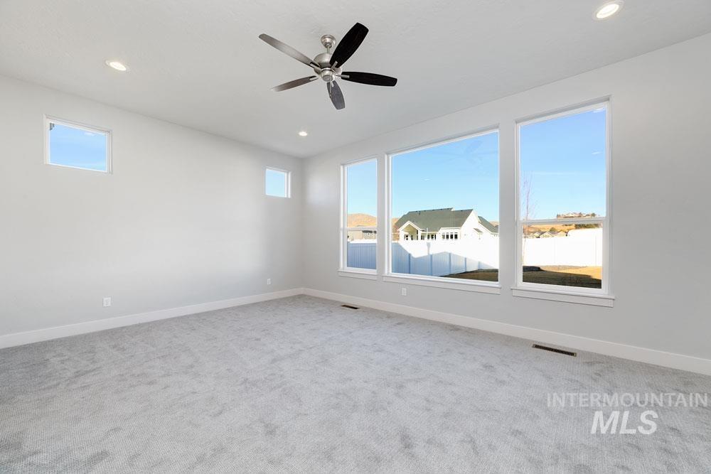 Spare room featuring light carpet, recessed lighting, and a ceiling fan