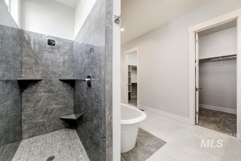 Bathroom featuring a walk in shower, a freestanding bath, and a spacious closet