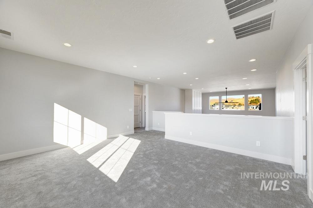 Carpeted spare room featuring recessed lighting