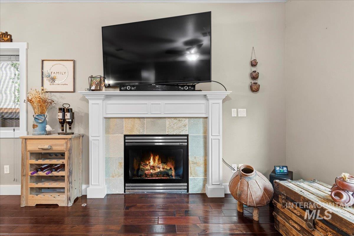 Living area featuring a tile fireplace and dark wood-style floors