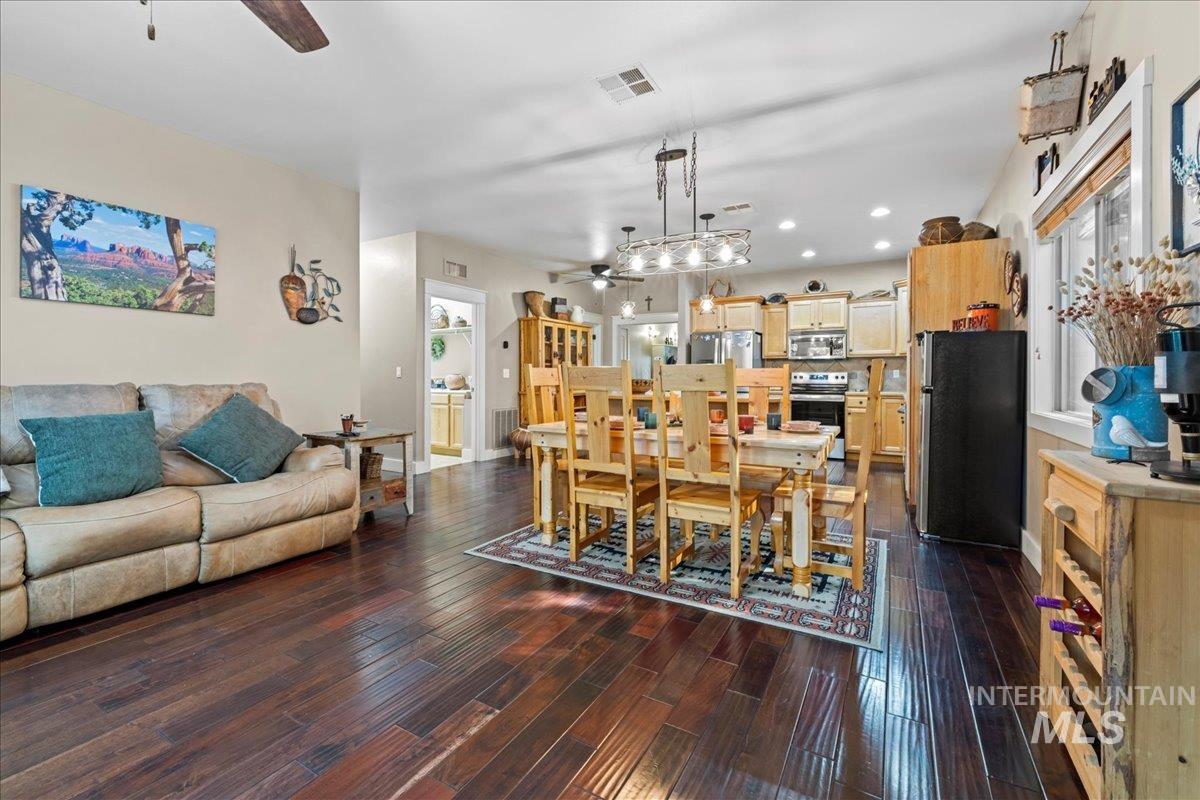 Dining room with ceiling fan, dark wood-type flooring, and recessed lighting