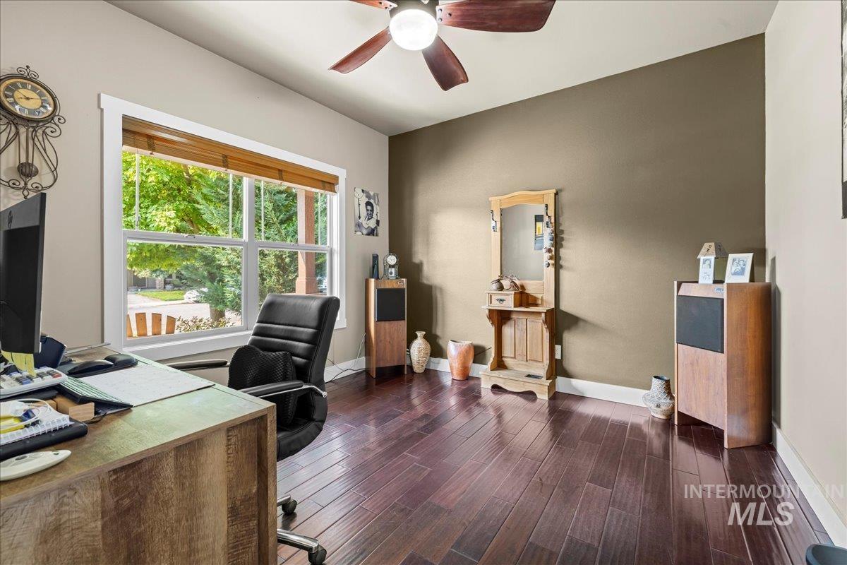 Home office featuring dark wood-style floors and a ceiling fan