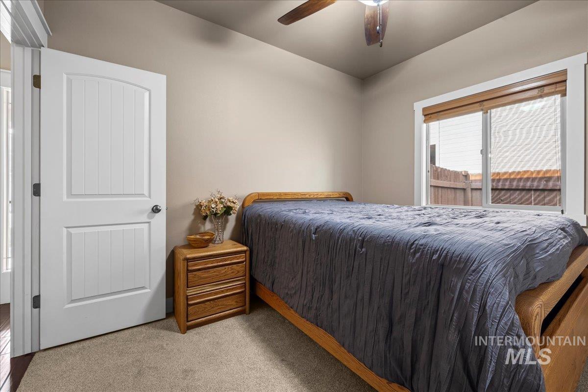 Carpeted bedroom featuring a ceiling fan