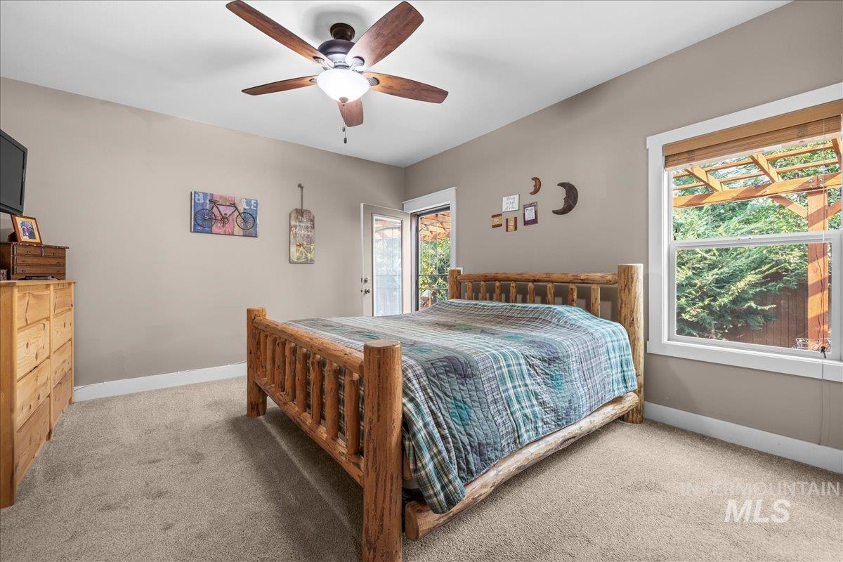 Carpeted bedroom with baseboards and ceiling fan