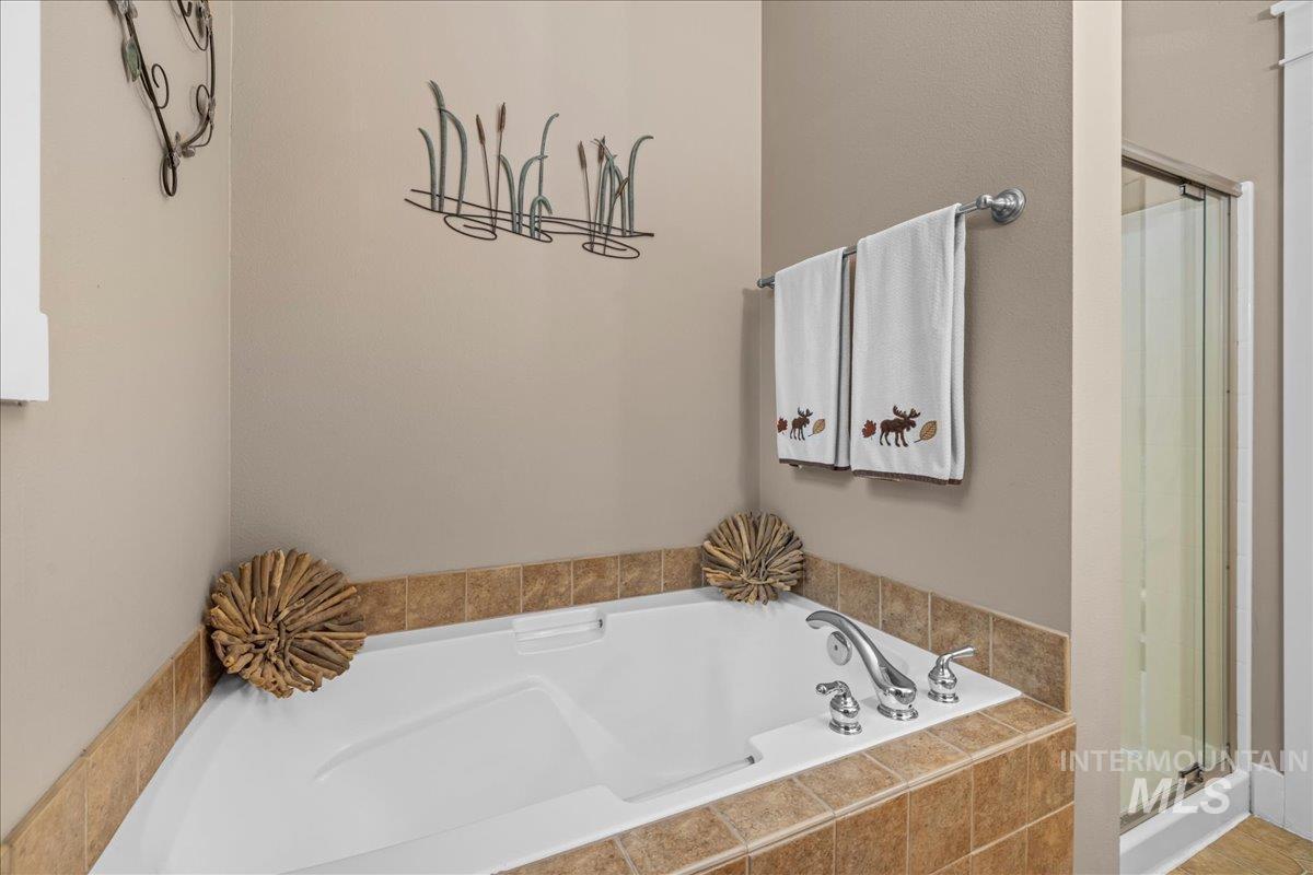 Full bath with a garden tub and a stall shower
