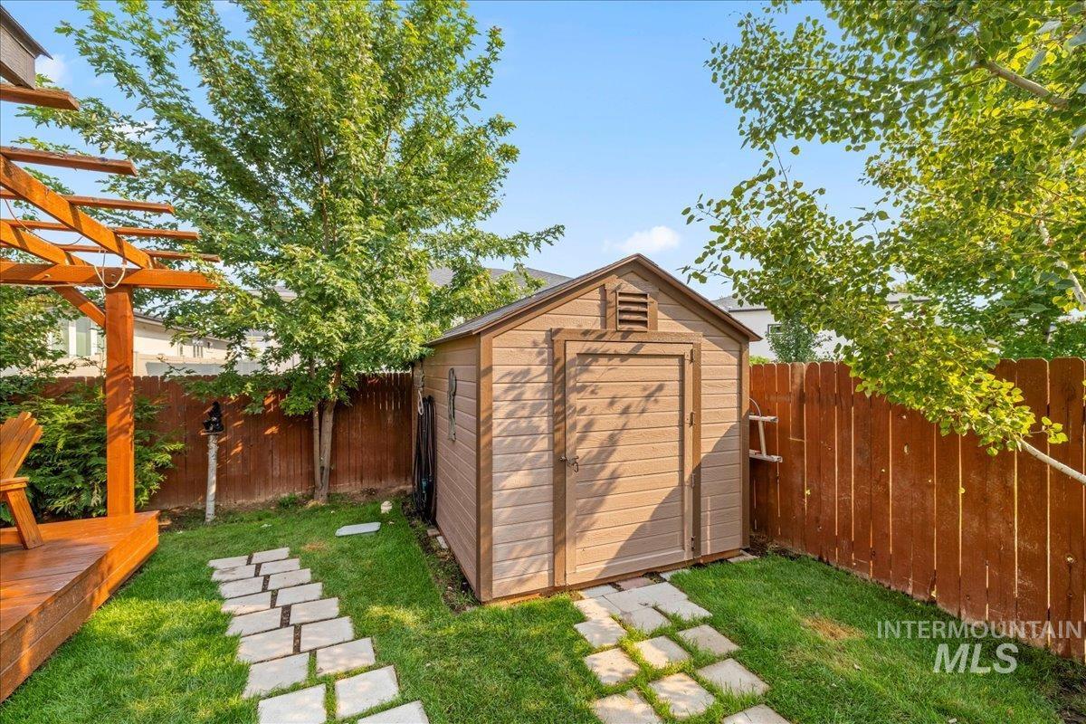 View of shed featuring a fenced backyard and a pergola