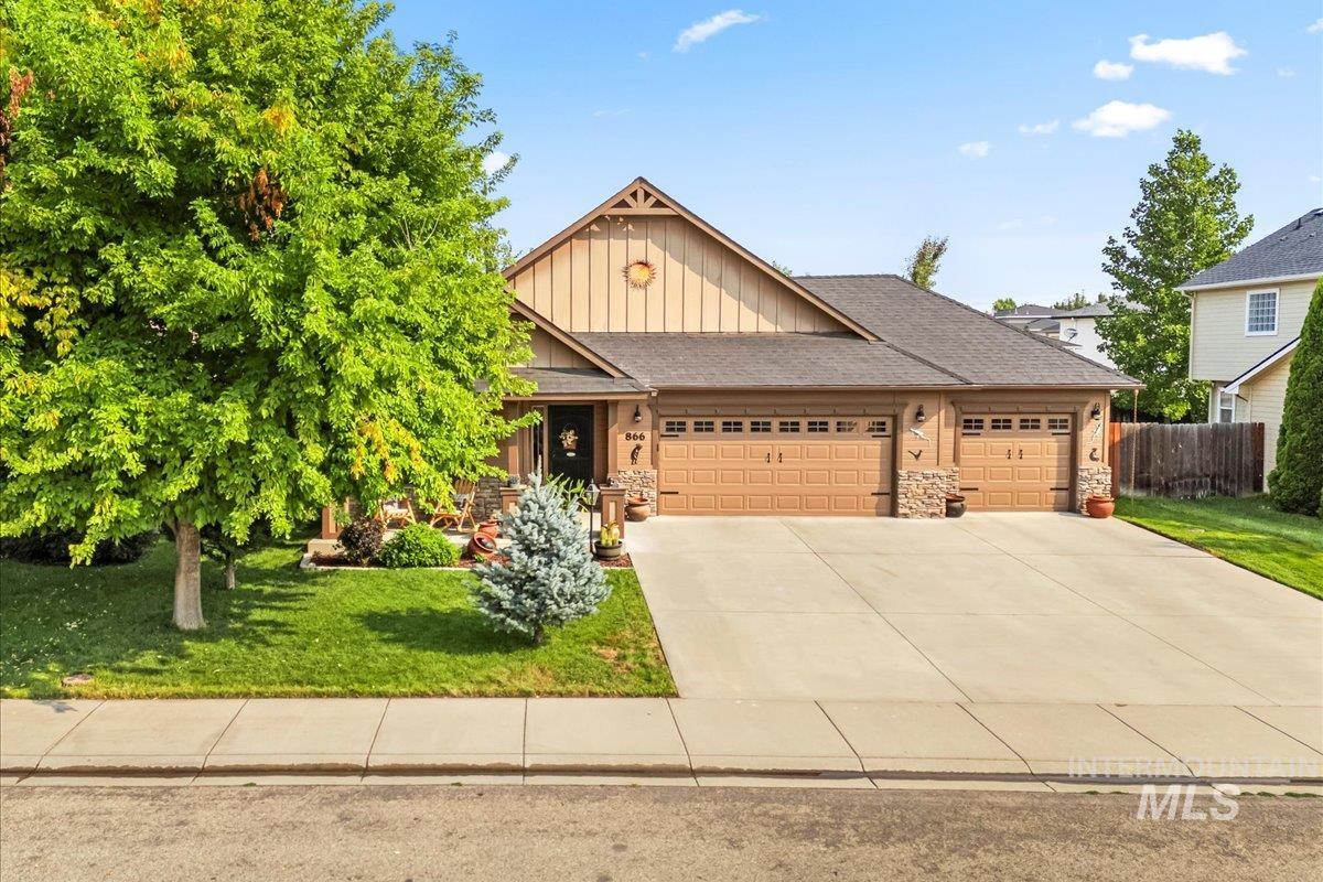 Craftsman inspired home featuring board and batten siding, a garage, a shingled roof, concrete driveway, and stone siding