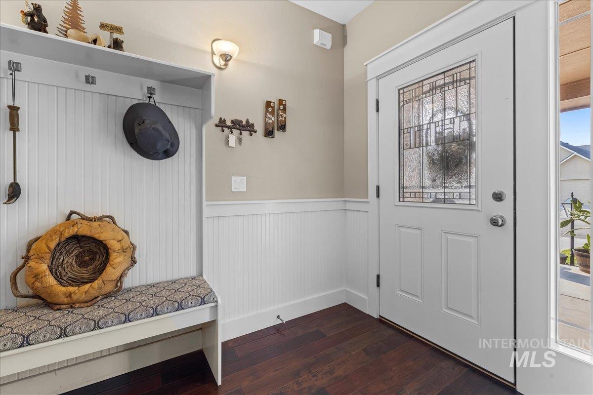 Mudroom with plenty of natural light, dark wood-type flooring, and wainscoting