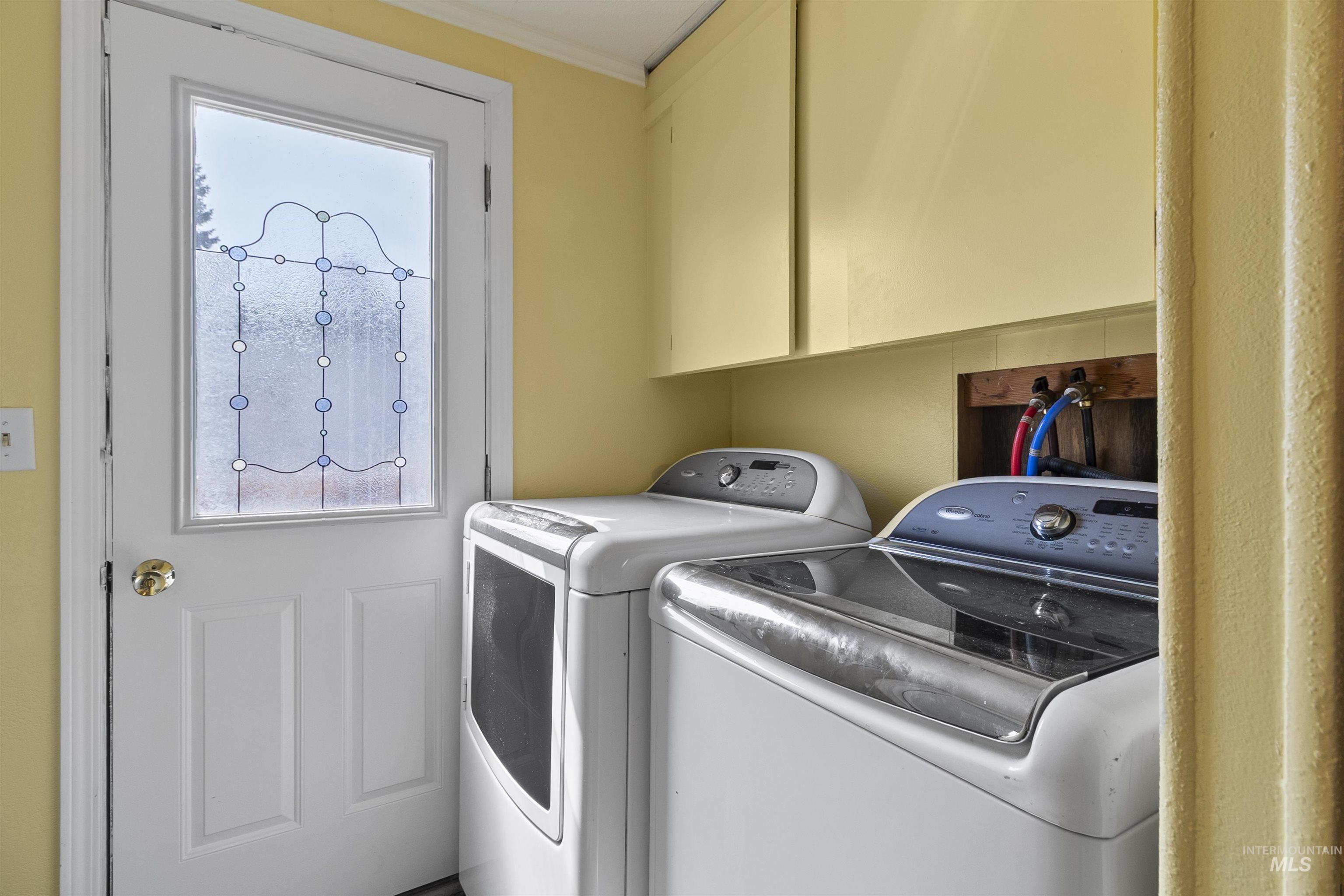 Washroom featuring washing machine and dryer and cabinet space