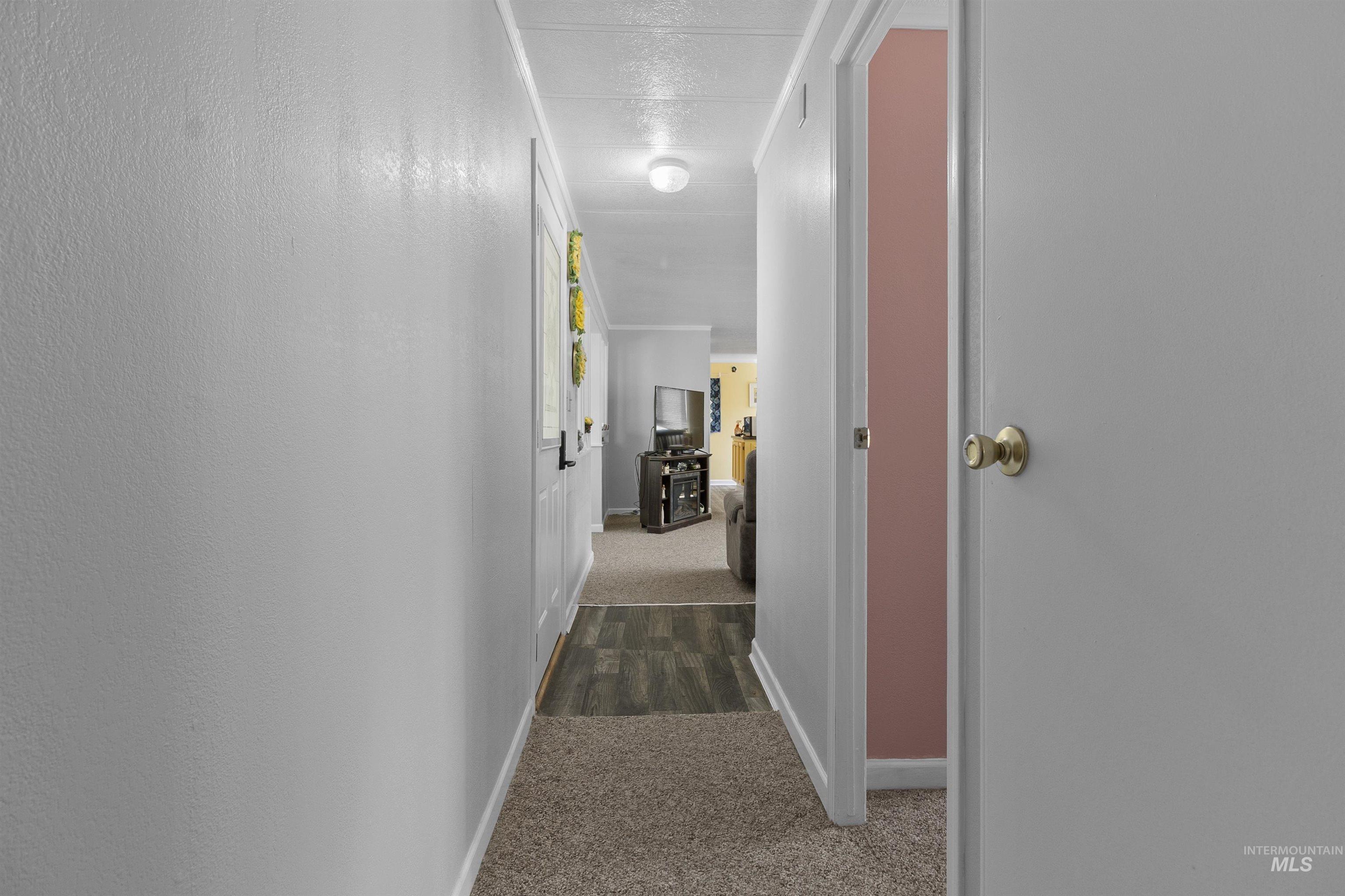 Hall with dark carpet and baseboards