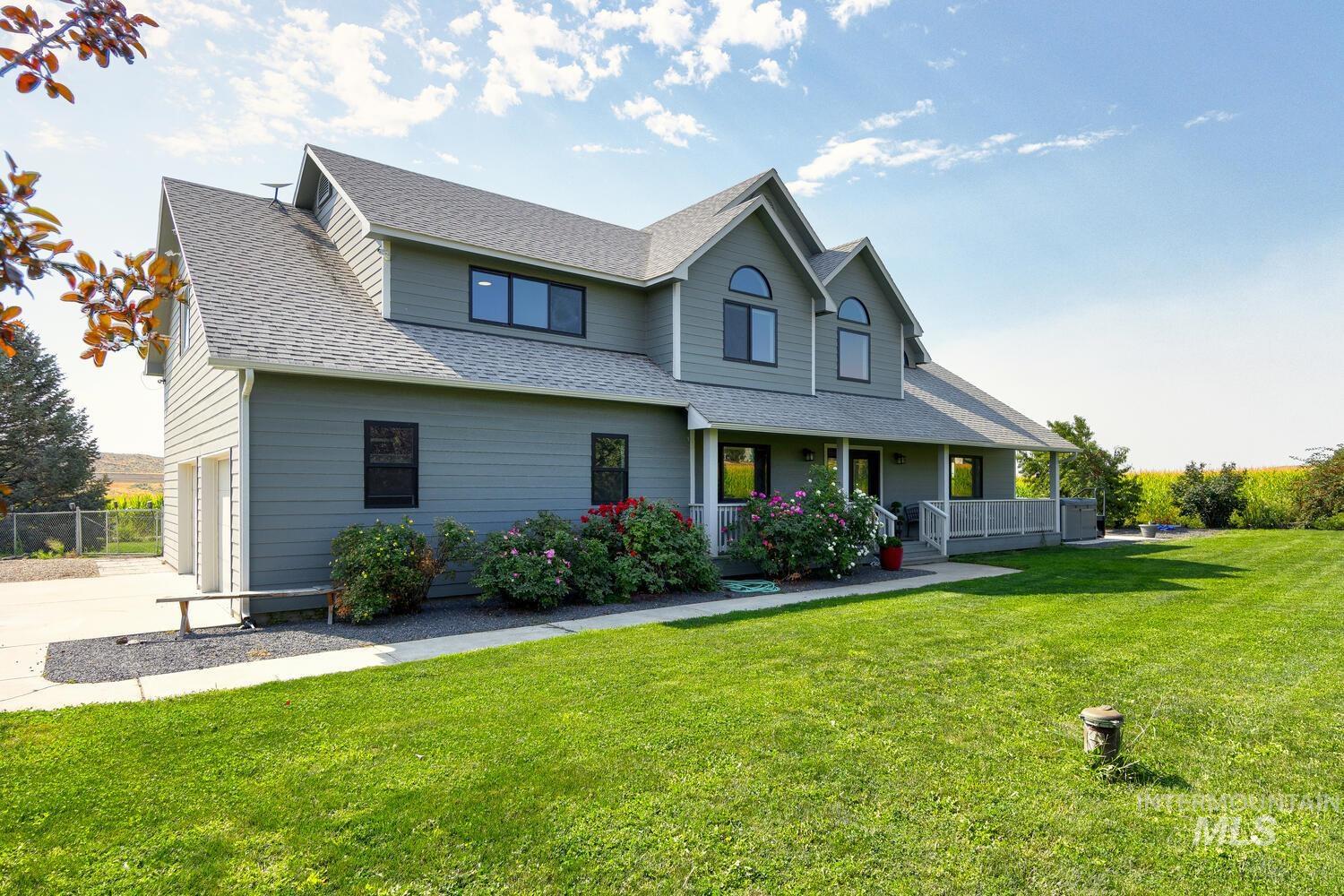View of front of property with a shingled roof, covered porch, a garage, and concrete driveway