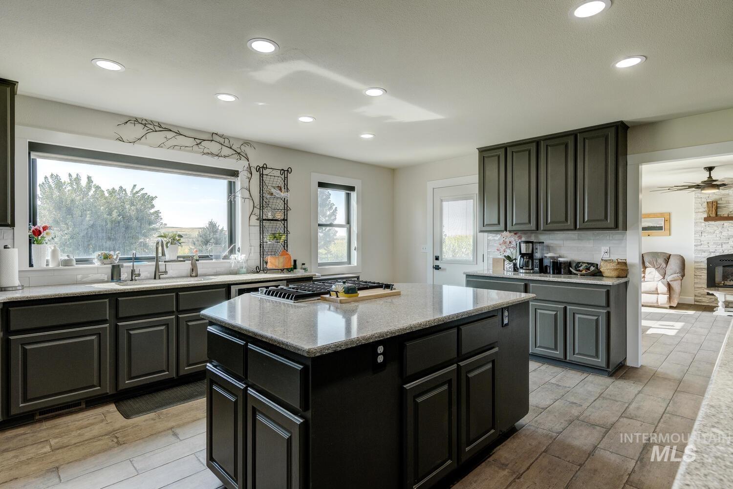 Kitchen with recessed lighting, tiled flooring, quartz countertops, a kitchen island, and decorative backsplash