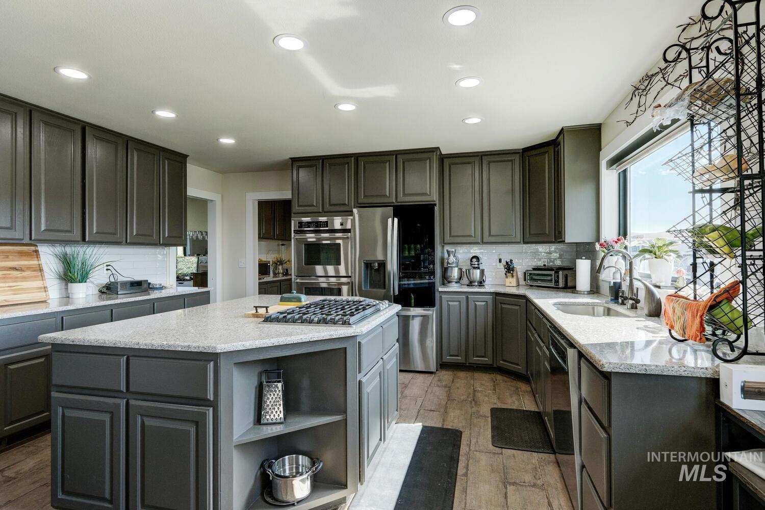 Kitchen featuring backsplash, appliances with stainless steel finishes, recessed lighting, and a kitchen island