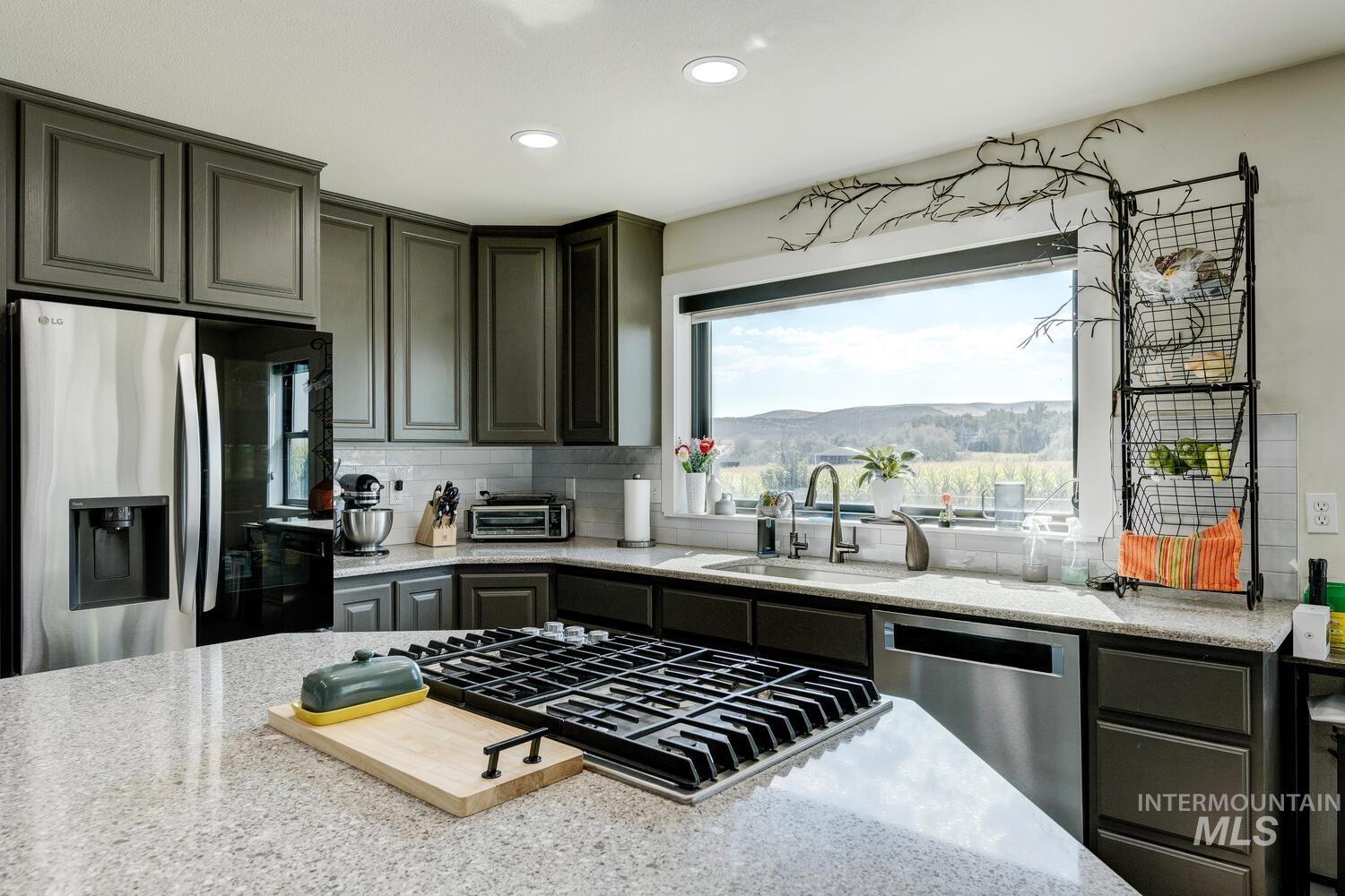 Kitchen with stainless steel appliances, gas cooktop, double ovens, backsplash, quartz countertops, recessed lighting, and gray cabinetry