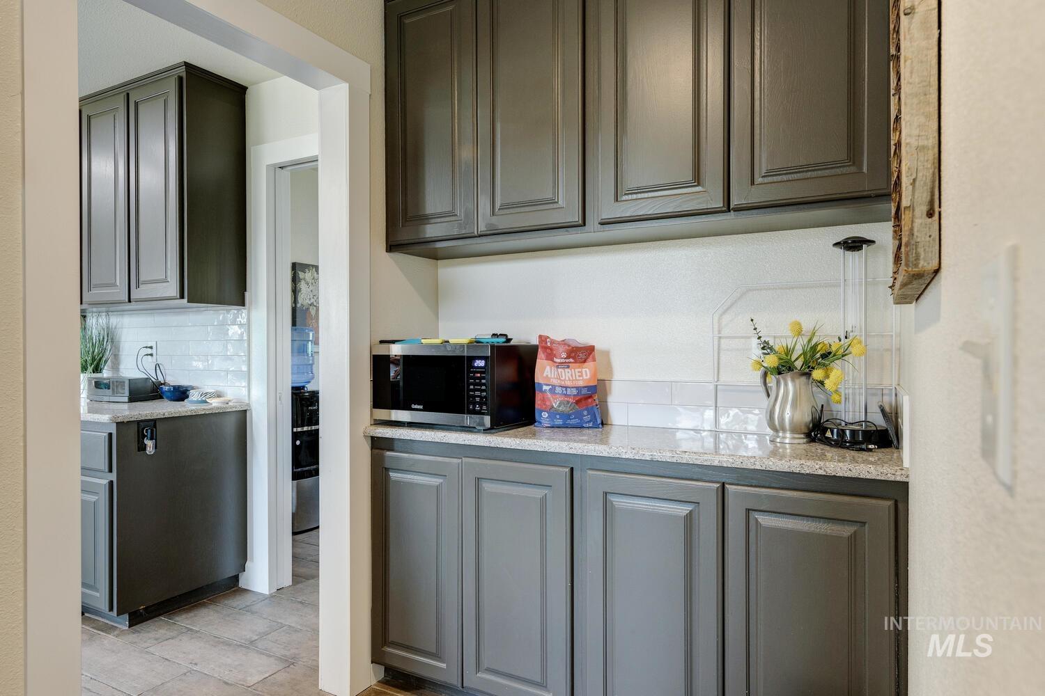 Gray cabinetry, decorative backsplash, quartz countertops