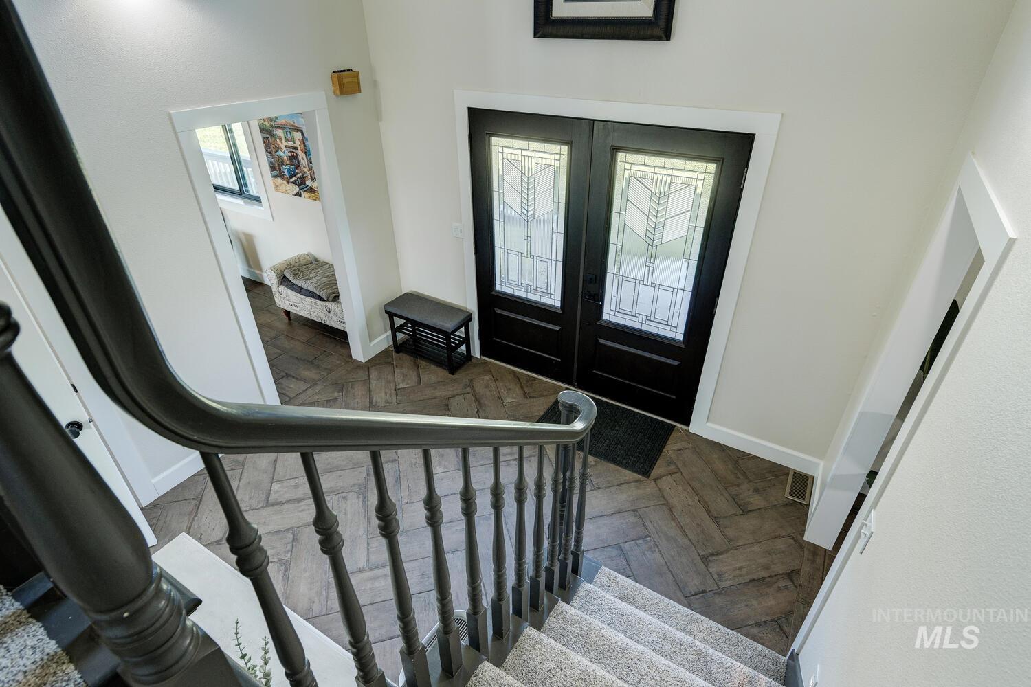 Foyer with french doors, stairs, and healthy amount of natural light