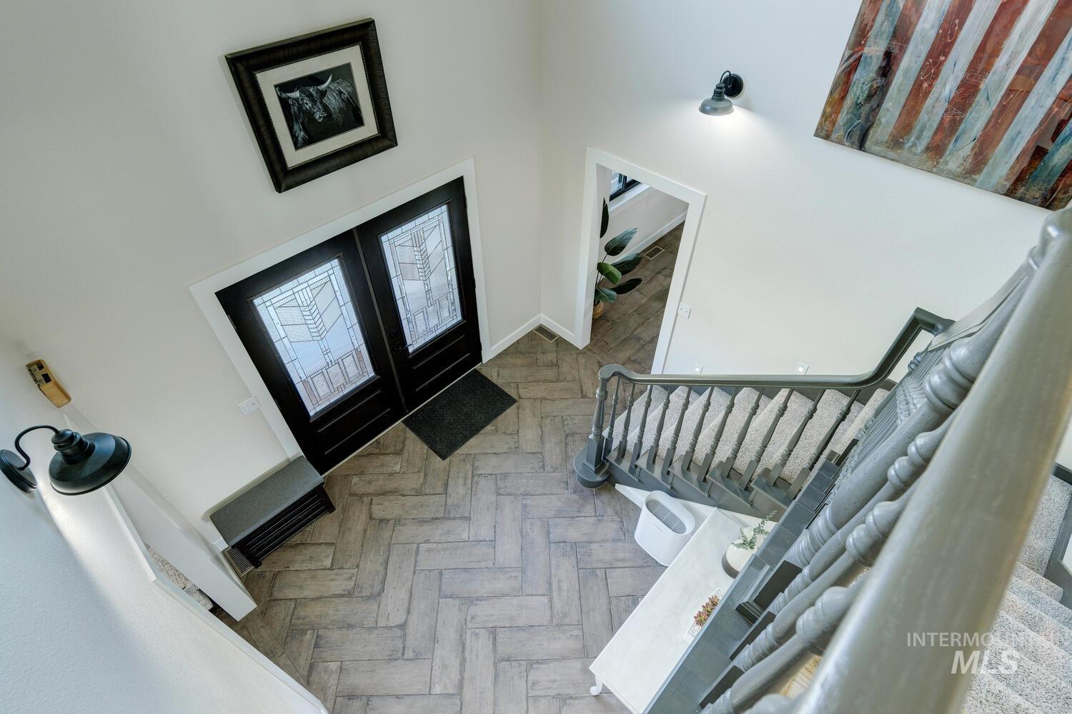Entrance foyer with stairs, french doors, and a towering ceiling