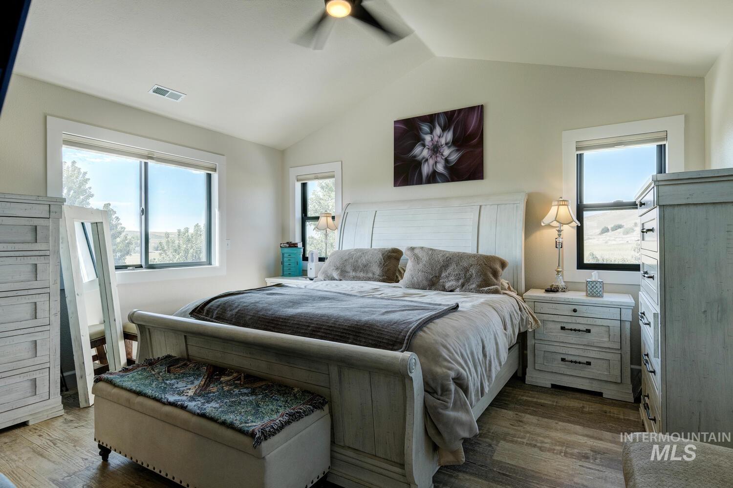 Bedroom featuring LVP flooring, vaulted ceiling, and a ceiling fan