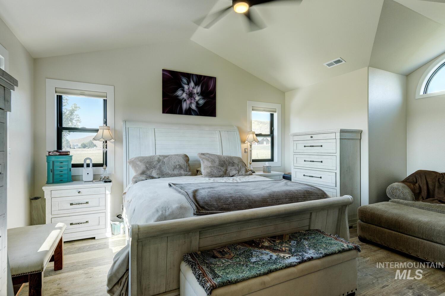 Bedroom with LVP flooring, vaulted ceiling, and ceiling fan