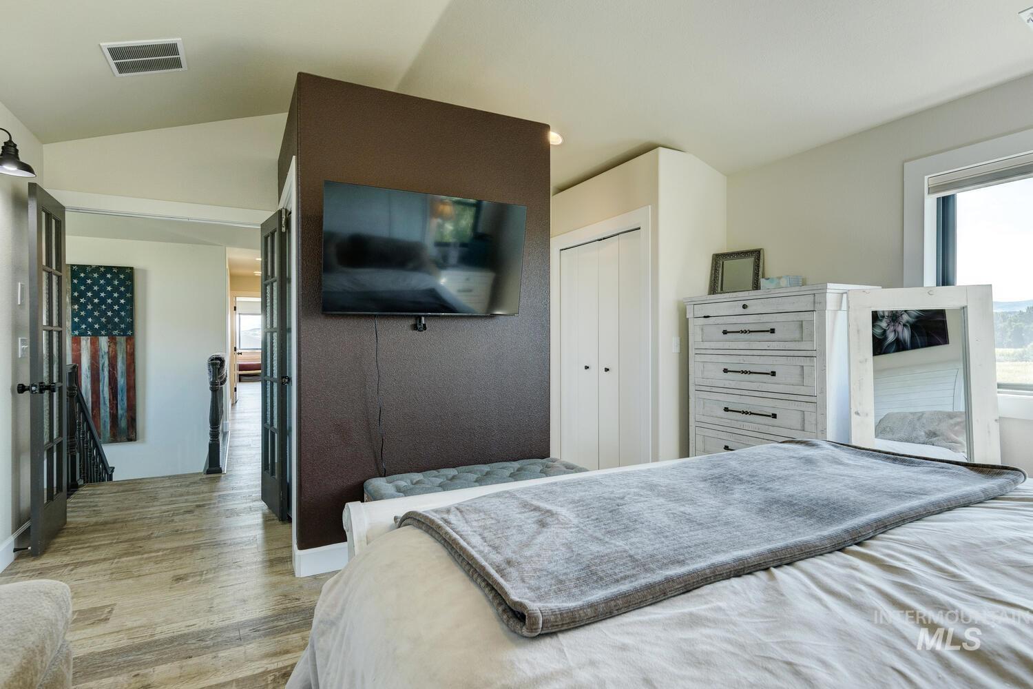 Bedroom featuring LVP floors, a closet, and vaulted ceiling